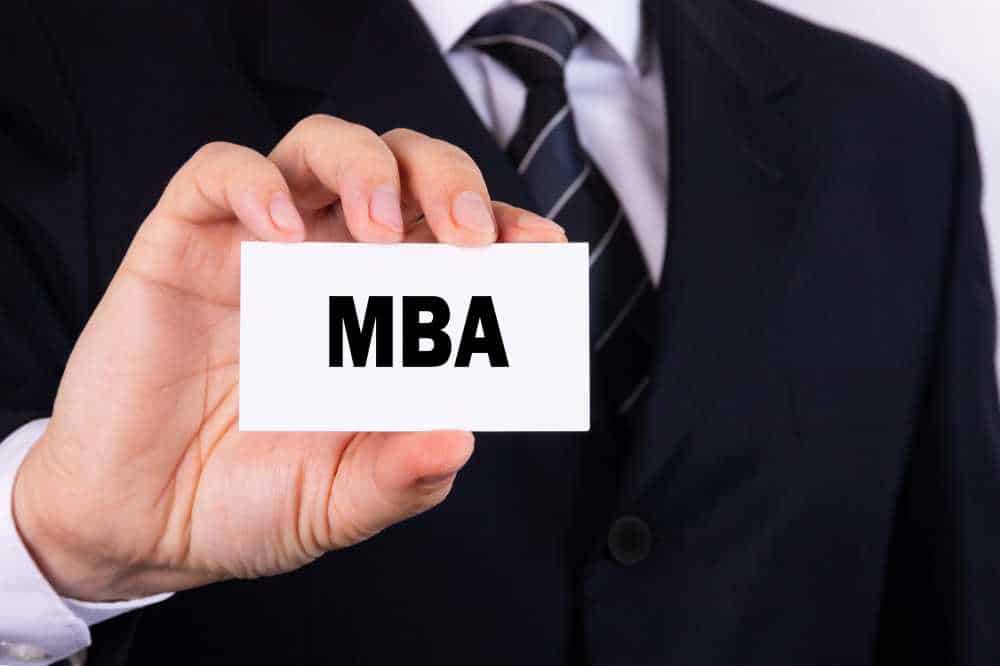 Image of a man holding a business with the words MBA